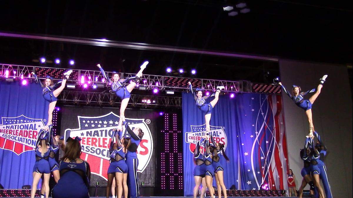 Abby Strohmetz, far left, stands atop her teammates hands as the flier during a routine at a competition in Atlanta last month.