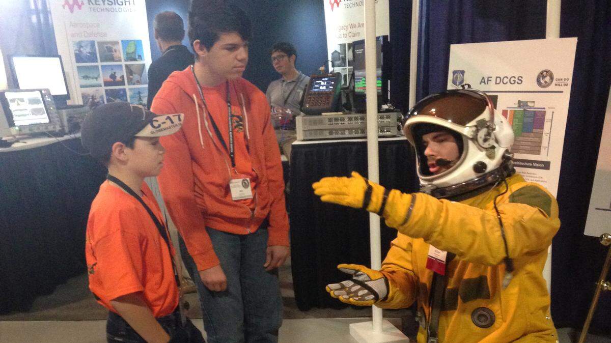 Jack and Ben Hartman listen as William Deaver, right, explains how a chase car helps the U-2 airplane land at the Dixie Crow Symposium 40 at the Museum of Aviation.
