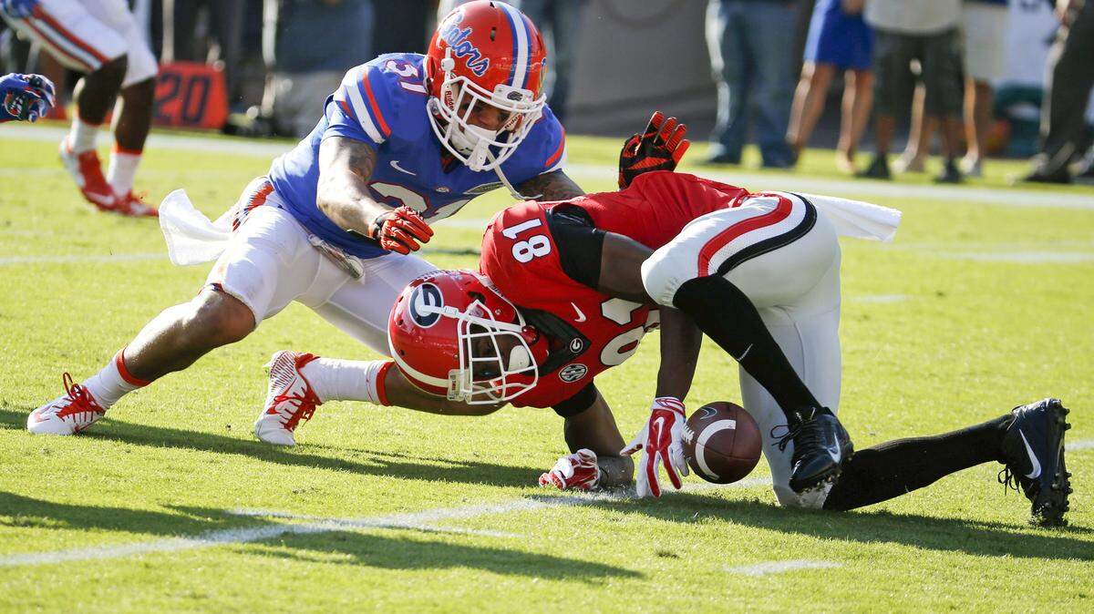 Georgia wide receiver Reggie Davis (81) fumbles a punt as Florida's Antonio Riles (51) goes for the ball during the first half of an NCAA college football game Saturday in Jacksonville, Florida. Florida recovered the ball for a touchdown in the end zone. 