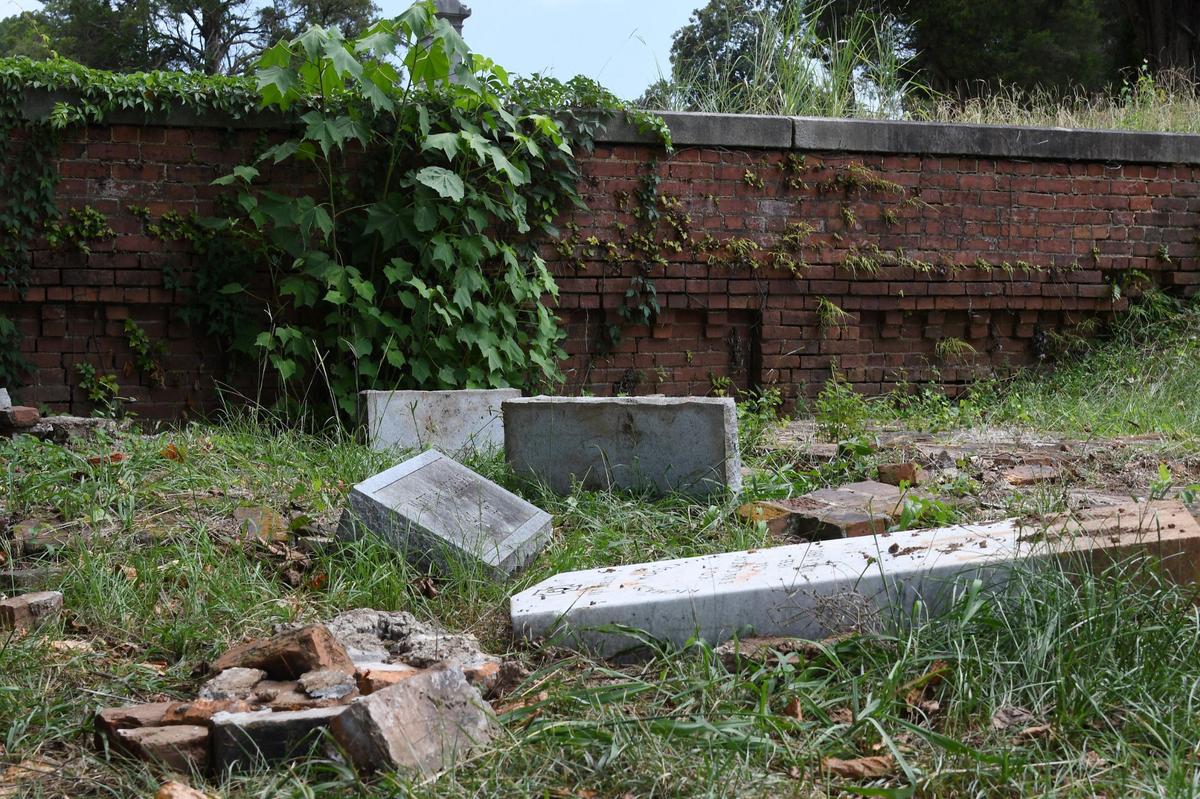 Headstones from the Woolfolk family sit overturned in the Rose Hill Cemetery on Wednesday, July 17, 2024, in Macon, Georgia. The Woolfolk family marker includes nine family members who were murdered in 1887. The area was vandalized this month.