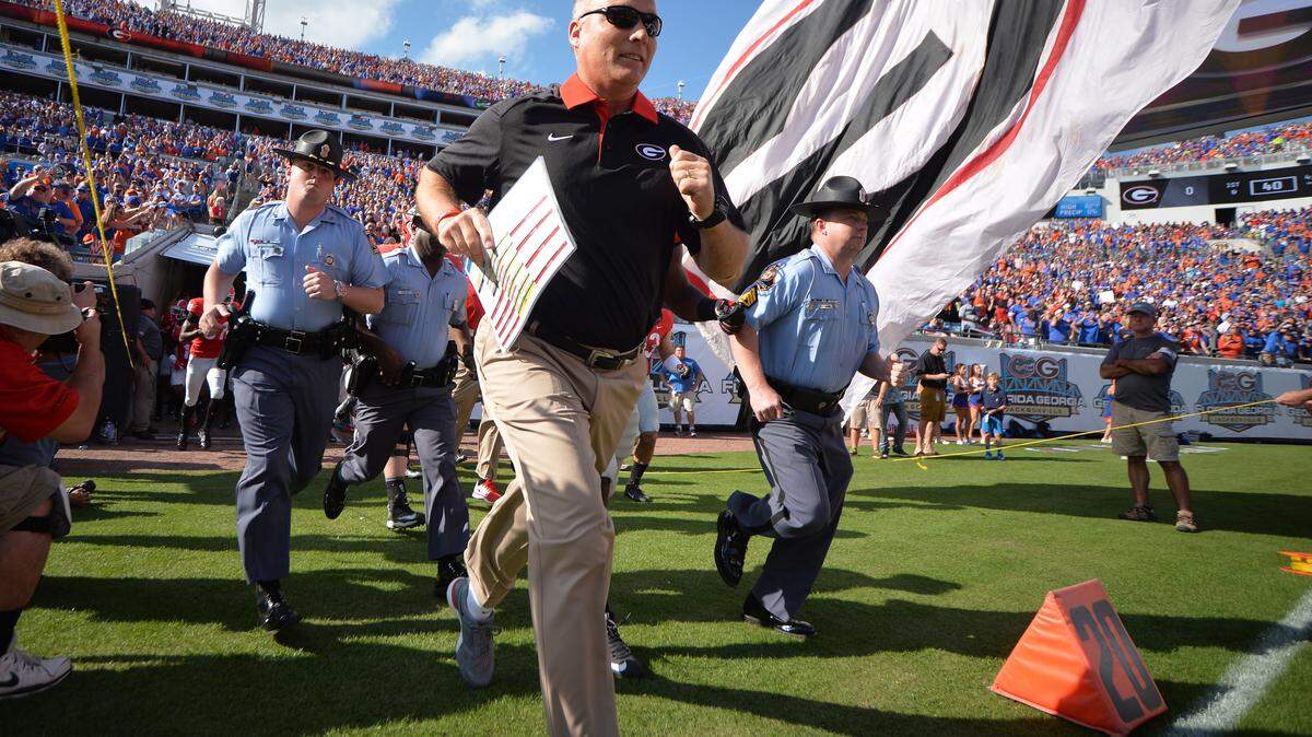 Georgia Head Coach Mark Right leads the Bulldogs on to the EverBank Field In Jacksonville, Florida in their Match-up with the Florida Gators.