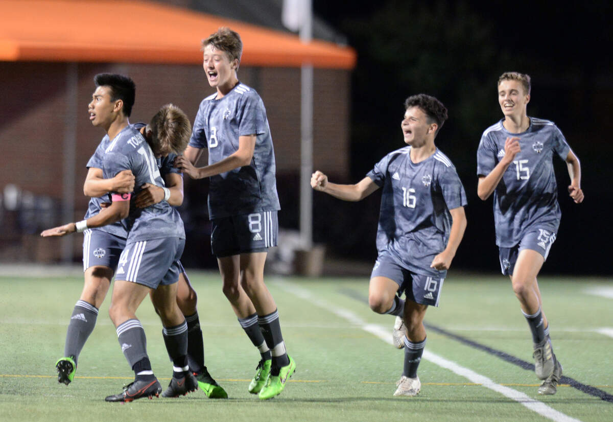 GMC striker Ethan Tolentino (14) celebrates with teammates after scoring a goal during the BulldogsÕ GHSA 1A State Championship match against ACE Friday night at Mercer.