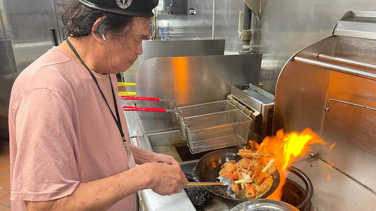 Quang Pham, who owns Saigon Bowl, a new authentic Vietnamese bistro in Warner Robins, with his wife, Thao Le, tosses a lobster dish called “tom hum rang muoi” on Wednesday, June 18, 2025.