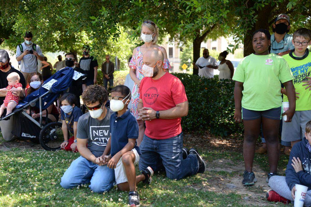 Bibb County residents kneel and pray during a rally at Rosa Parks Square in downtown Macon. The event featured speeches, prayers and a song calling for positive change in America.