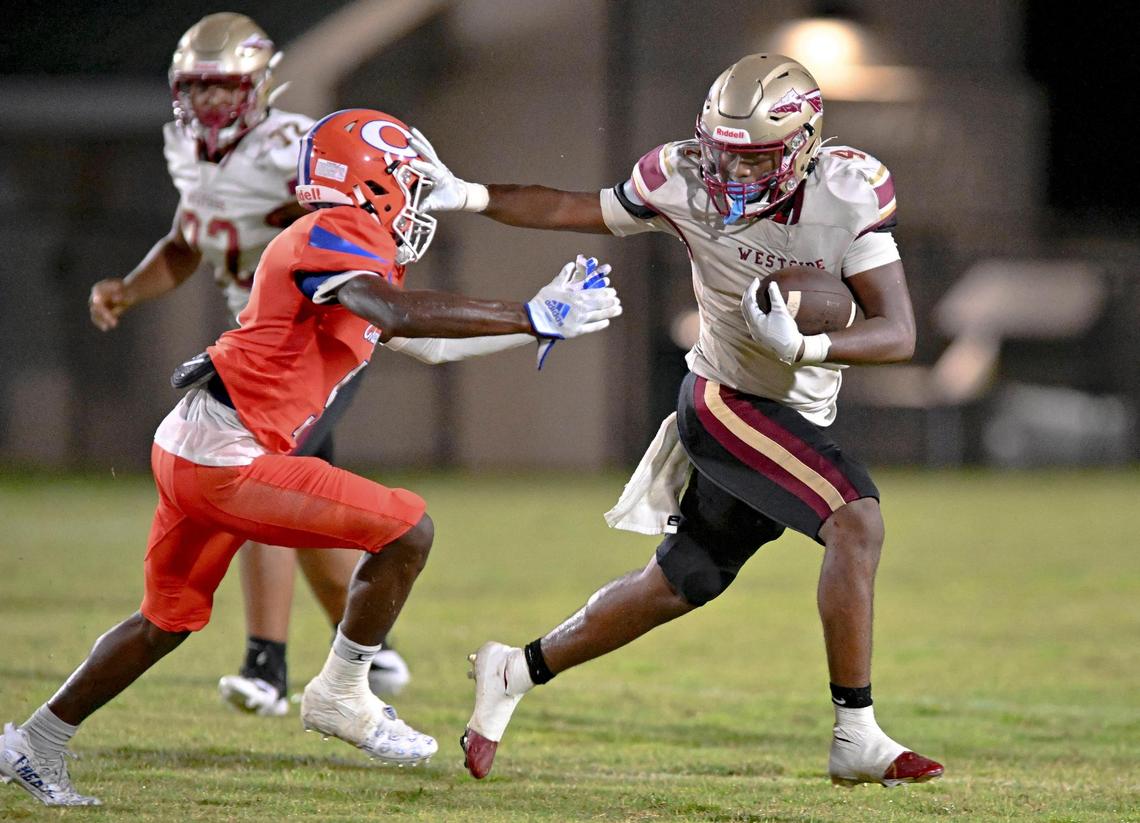DONN RODENROTH,Macon, Georgia, 08/19/2022: Westside High running back Kadiphius Iverson shoves off a Central defender and picks up a first down in action Friday night at Henderson Stadium.