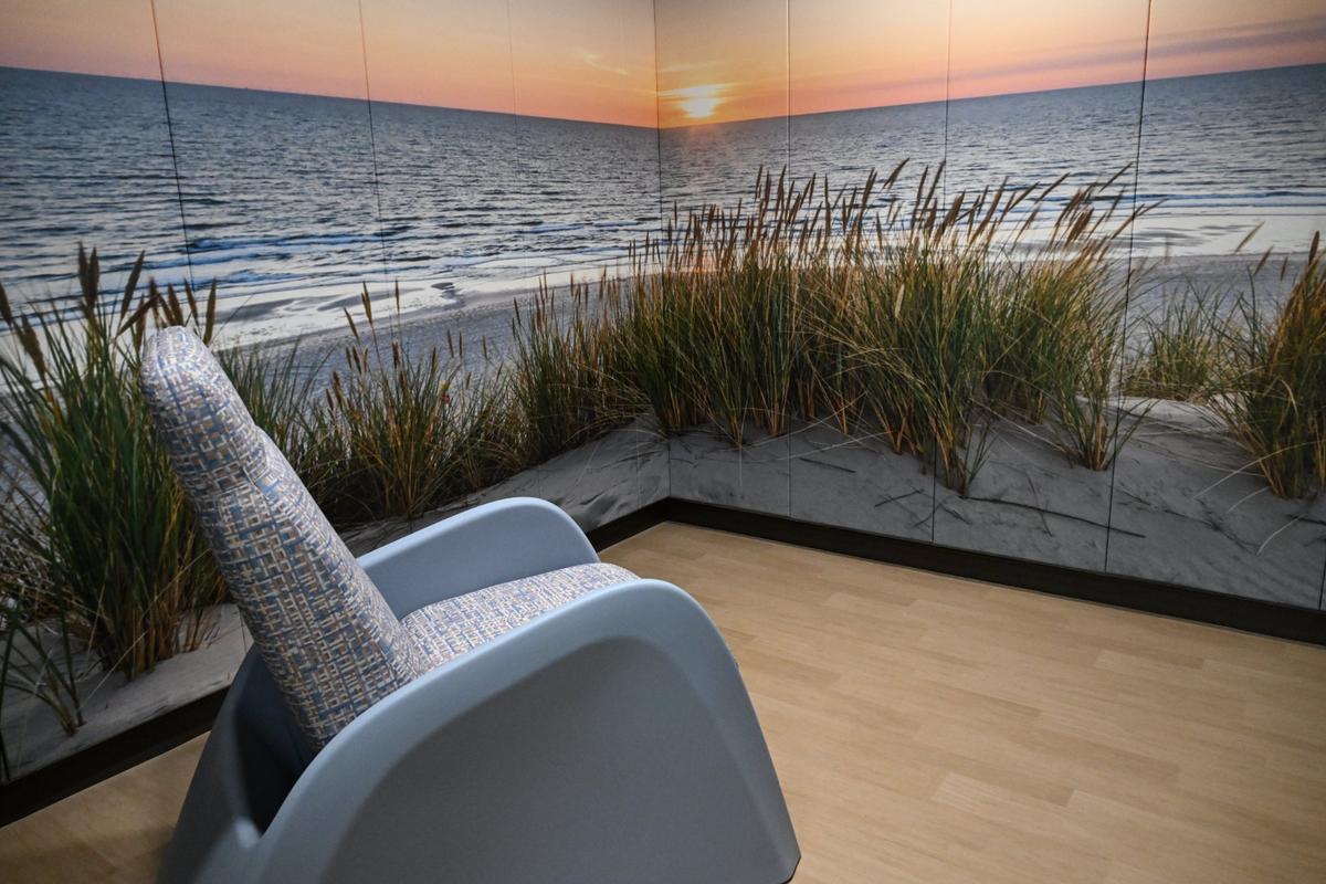 A chair sits in a room with beach scenery walls in one of the calming rooms at River Edge Crisis Services and Diagnostic Center on Thursday, June 5, 2025, in Macon, Georgia. There are two small calming rooms in the center and are intentionally designed with scenery wallpaper, where walls are usually blank or a solid color.