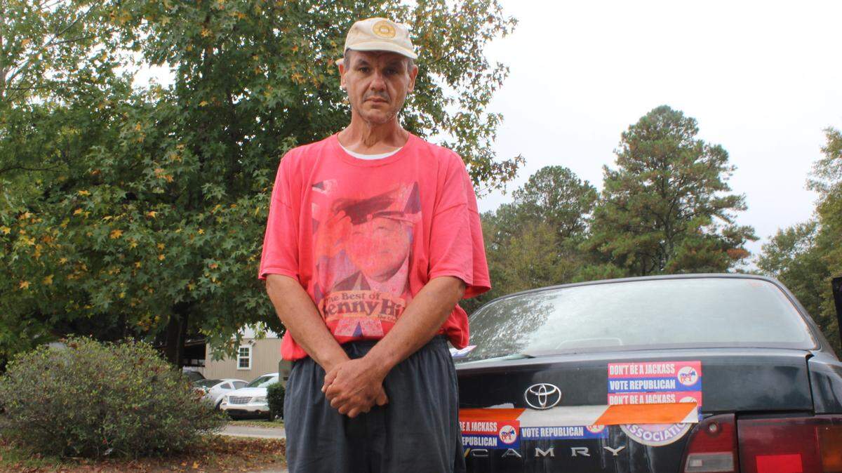 Juri Santacatterina, an Italian immigrant, stood by his car adorned with “Don’t be a jackass. Vote Republican” stickers on Friday, Nov. 8, 2024, in the Red Fox Run mobile home community in Warner Robins, Ga.