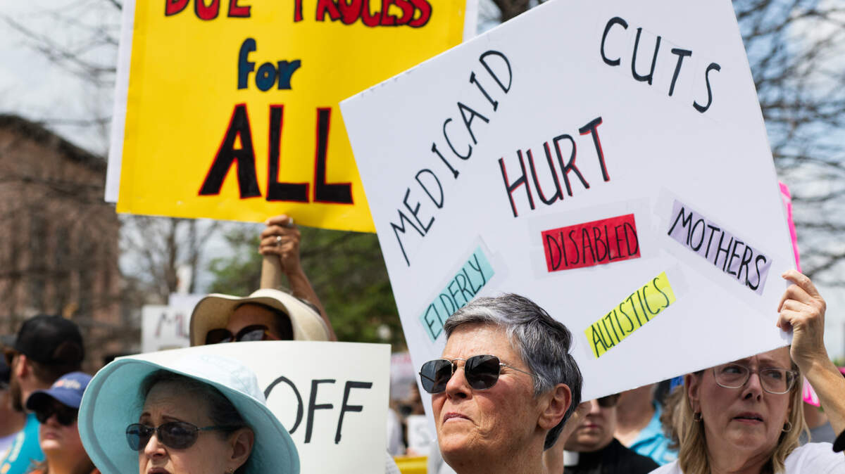 Demonstrators raise signs protesting against Medicaid cuts and calling for due process at a rally on April 5, 2025.