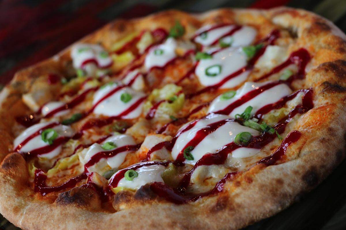 A buffalo chicken signature pizza from Smokin’ Oak Wood-Fired Pizza & Taproom. The pizza is made with buffalo sauce, mozzarella, chicken and banana peppers, baked in the wood-fired oven and then topped with fresh green onions, blue cheese dressing and scratch-made raspberry sauce, according to the menu.