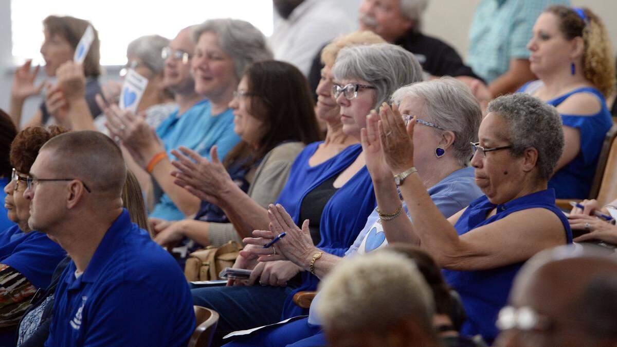 Library employees and supporters react to the Macon-Bibb County Commission passing funding that would enable the system to resume normal services in this August 2018 file photo.