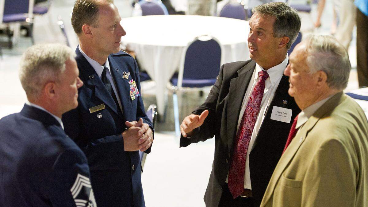 Chief Master Sgt. Thomas Lee, Col. Tim Brester, Warner Robins Mayor Randy Toms, and Houston County Commissioner Tom McMichael talk before the State of the Base address at the Museum of Aviation Tuesday.