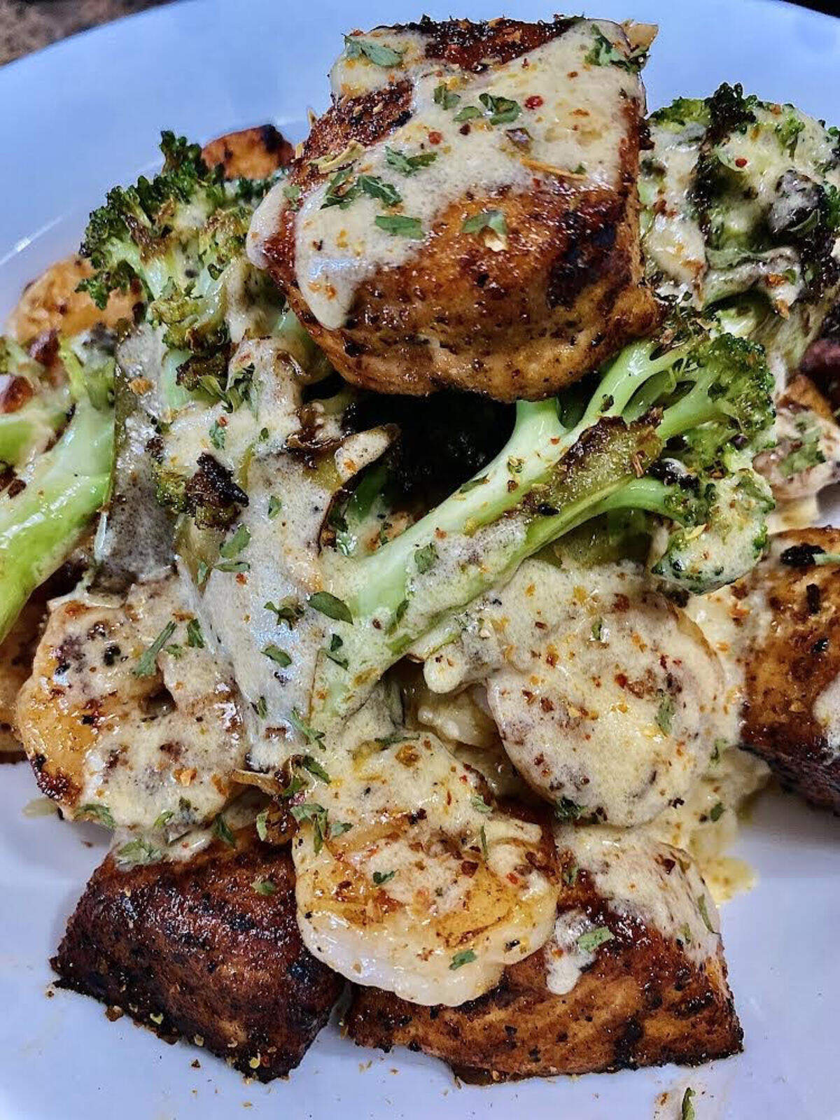 Salmon bites, sauteed shrimp and sauteed broccoli over risotto rice with a special sauce from ABC Catering LLC food truck.