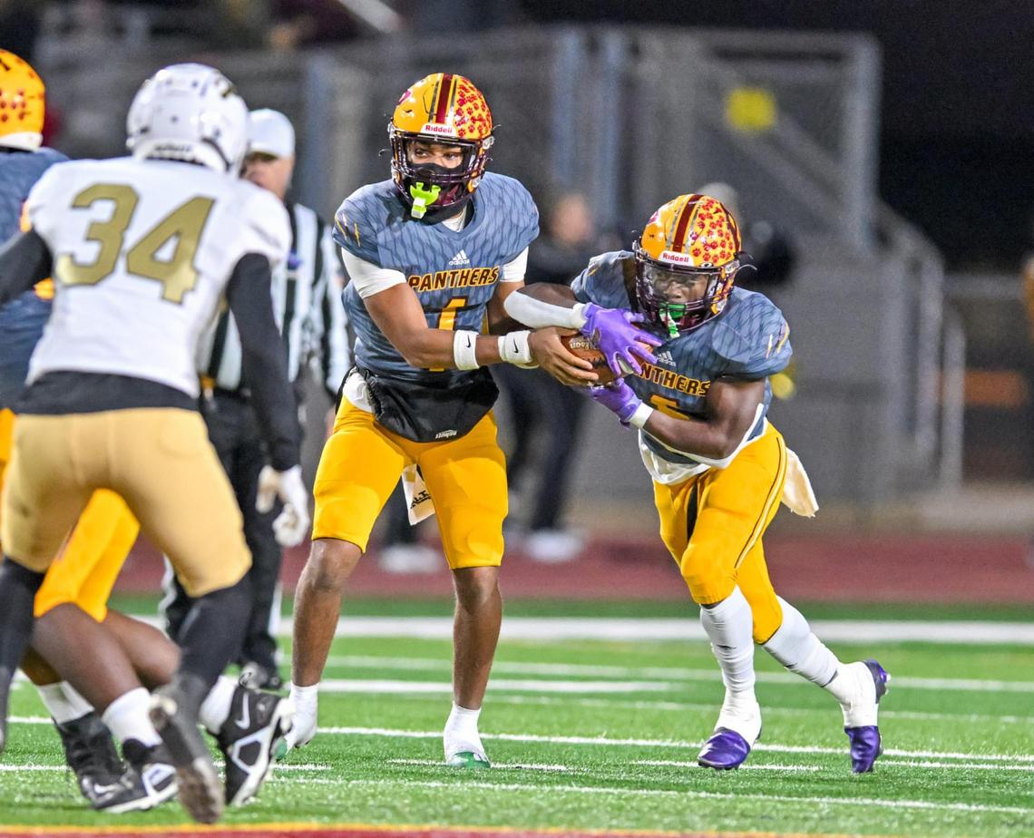 Perry quarterback Armar Gordon, Jr. hands off the ball to to running back Demetrious Carter in action Friday against Wayne County High.