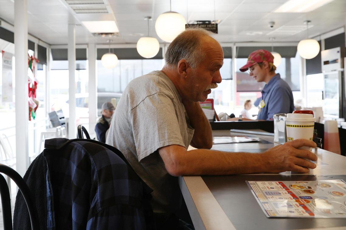Rick Mertens (left) sits at the counter of the I-75 Northbound Waffle House with a cup of coffee and talks with employee Taylor Pearson (right) of on Thursday, Dec. 5, 2024, in Byron, Georgia. Mertens works next store at an auto repair shop and comes in for a cup of coffee multiple times a day.
