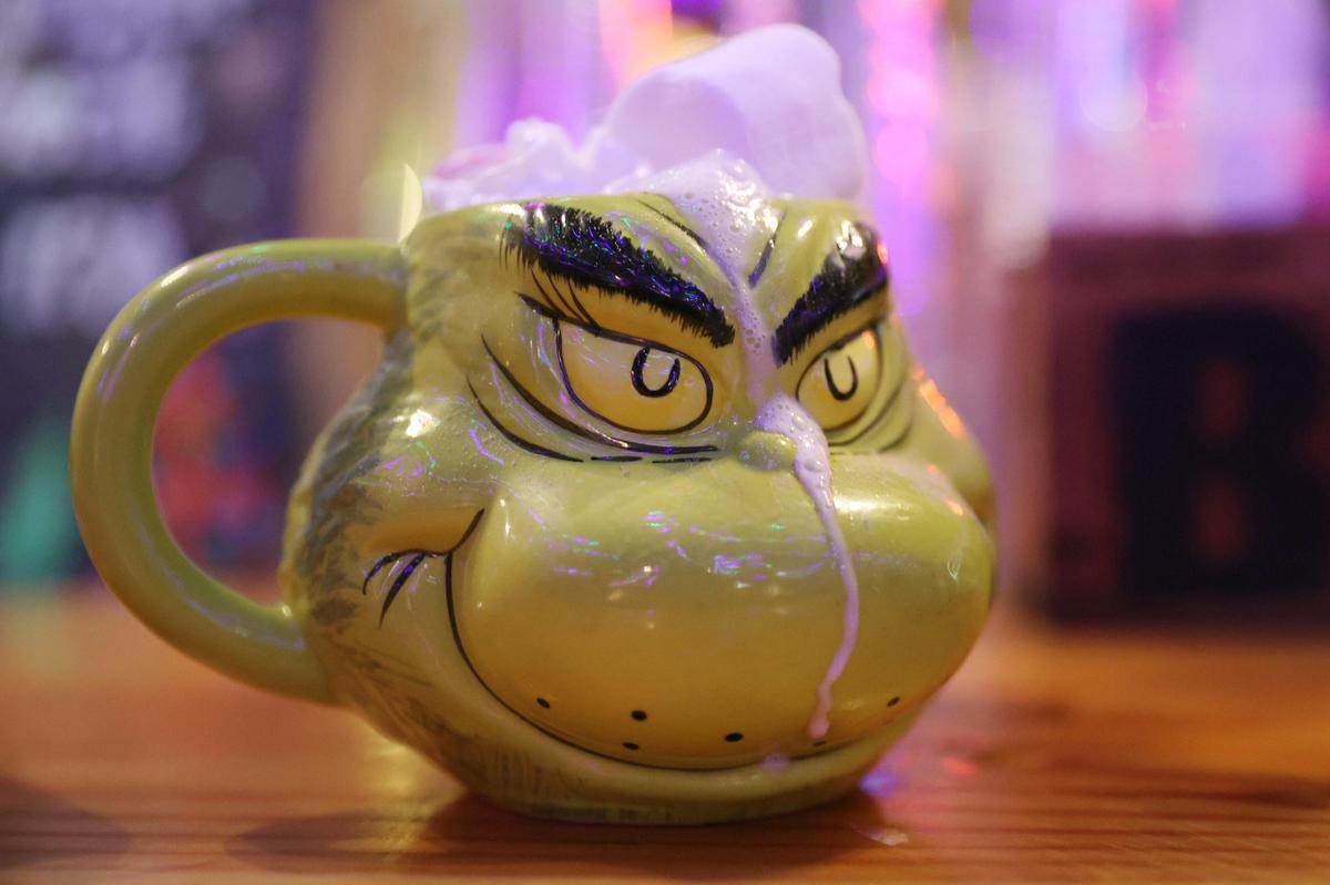 A mug of spiked hot chocolate in a Grinch mug sits on the bar at the Miracle on Ingleside pop-up Christmas bar at Society Garden on Thursday, Dec. 12, 2024, in Macon, Georgia. Miracle on Ingleside will be open throughout December with specialty holiday cocktails.