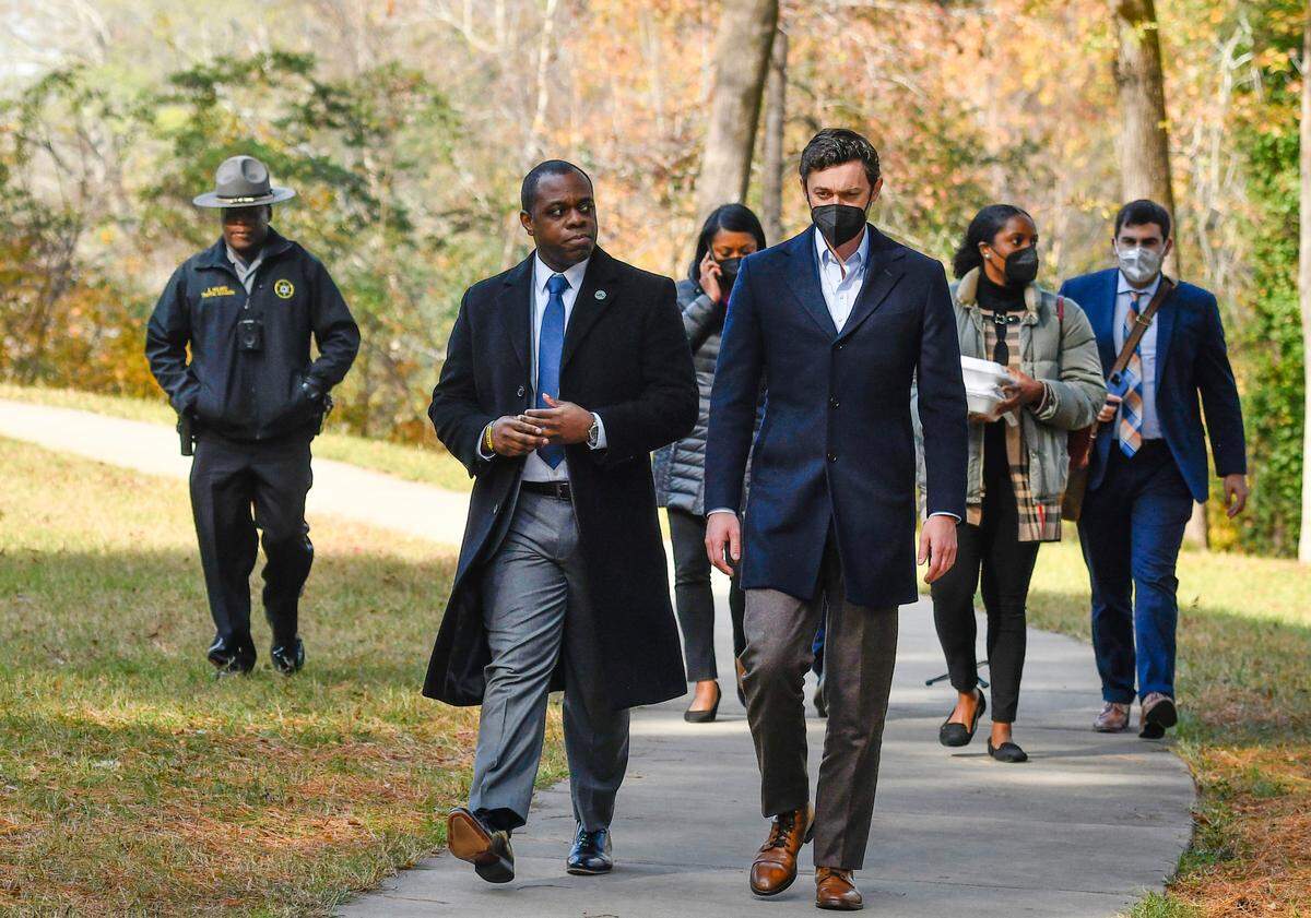 U.S. Sen. Jon Ossoff walks back to his car with Bibb County Commissioner Paul Bronson after speaking during a press conference Tuesday at Amerson River Park to discuss the passing of a bipartisan infrastructure bill.