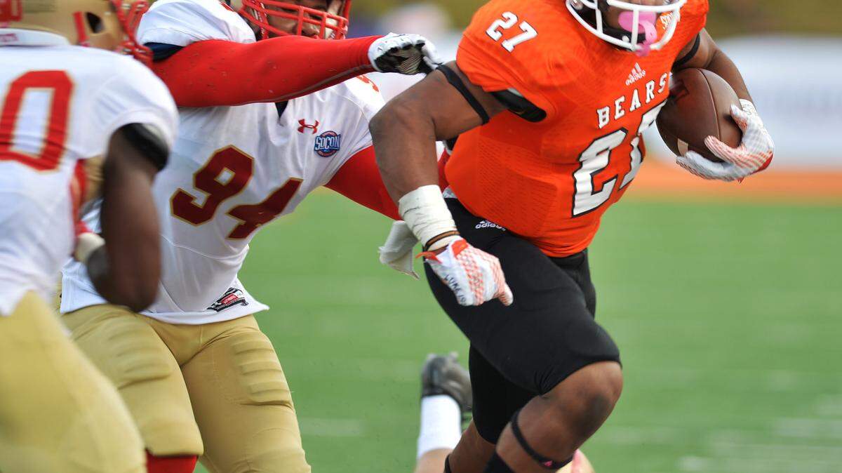 Mercer running back Alex Lakes is driven out of bounds by VMI's Amon-Ra Clay in the fourth quarter. VMI held on to an early lead and beat Mercer, 28-21.