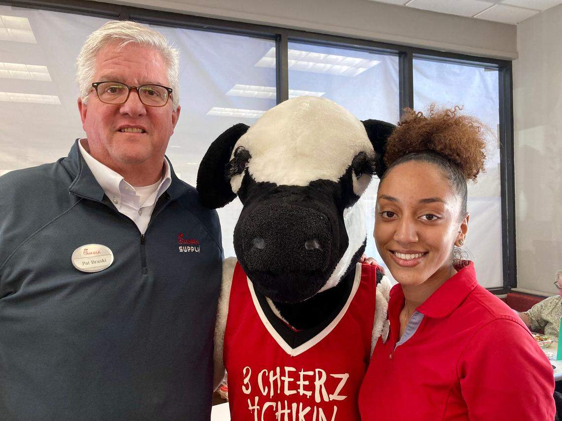 Pat Braski, a Chick-fil-A owner and operator, with the cow mascot (Mackenzi Toftee) and employee Kyla Bembey at 1867 Watson Blvd. location that closed Friday. The new location at 621 Russell Parkway opens Thursday. Braski dressed up as the original mascot, Doodles the rooster, in 1986. “By the time I was in the costume, I was a 7-foot chicken,” Braski recalled with a laugh.