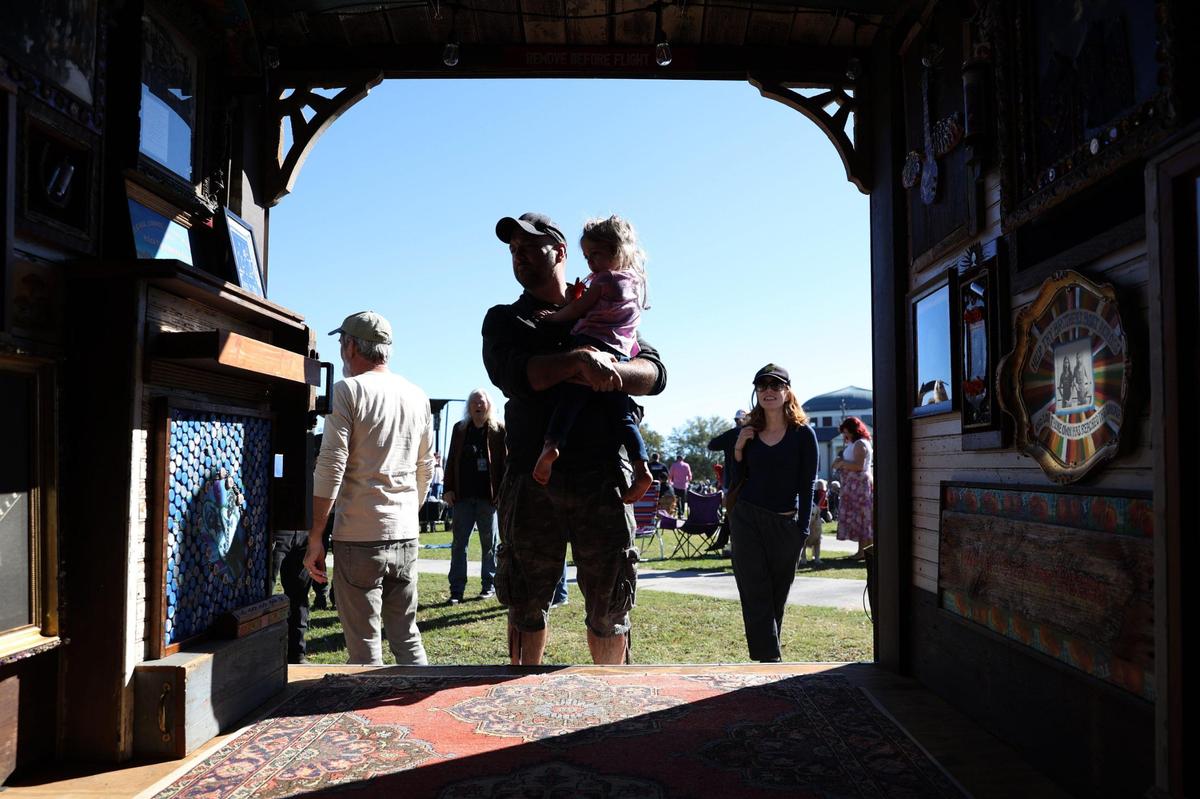 Attendees at Skydog Festival, an annual music festival honoring Duane Allman’s music legacy, look inside of The Church of Duane Allman on Sunday, Nov. 24, 2024, during Skydog Festival at Carolyn Crayton Park in Macon, Georgia. John Mollica created The Church of Duane Allman art exhibit to showcase his art and share the legacy of guitarist and front man of The Allman Brothers Duane Allman, a key figure in Macon music history.