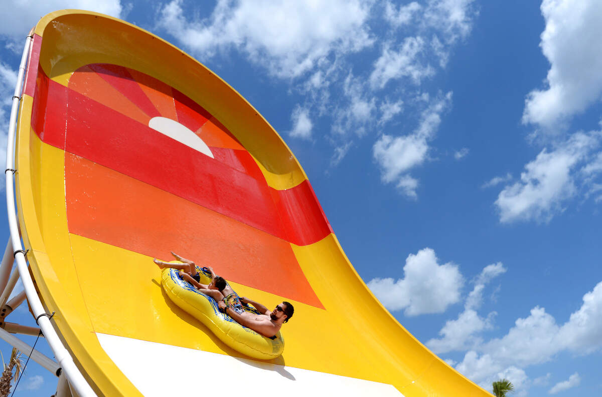 Tyler Hudlin and his son Talan ride the Boomerang, nicknamed the Wipeout, at Rigby’s Water World. Roughly 50 contest winners got to try out the slide tower before the park opened in July.