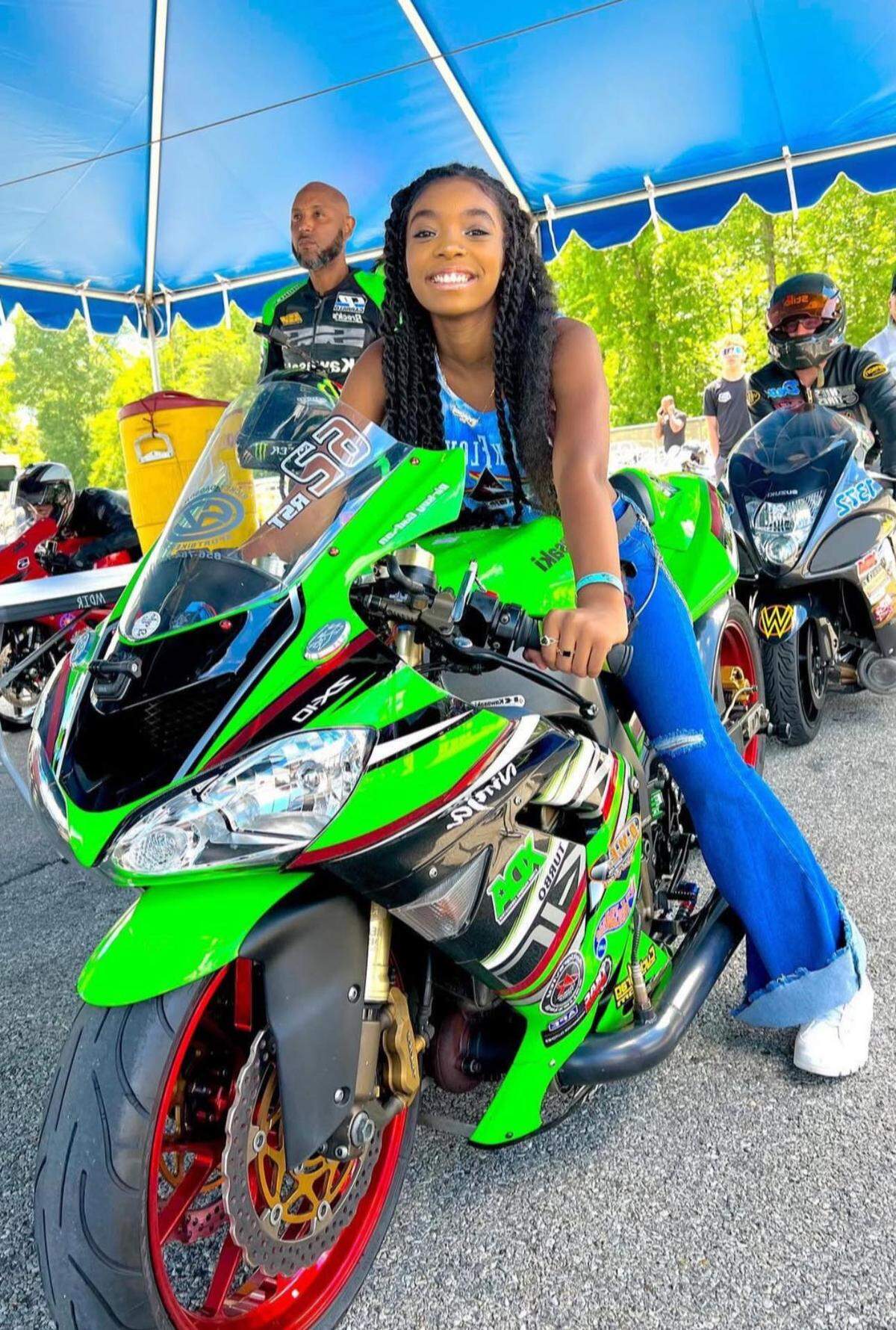 Laila Ali Gadson poses on a motorcycle next to her father, Rickey Gadson.