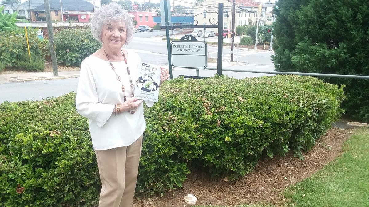 Estelle Herndon at her full-time job as a paralegal with her first book, “Finding His Strength” on Monday, September 24.