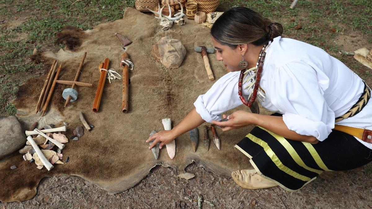 Walalalah Brown Tisho of the Eastern Band of Cherokee Indians places artifacts on a rug during the 2024 Ocmulgee Indigenous Celebration on Saturday, Sept. 14, 2024, at Ocmulgee Mounds National Historical Park in Macon, Georgia. Ocmulgee Mounds National Historical Park hosted its 32nd Ocmulgee Indigenous Celebration, which featured cultural dancing, storytelling and demonstrations from the Muscogee (Creek) Nation and other southeastern tribes.
