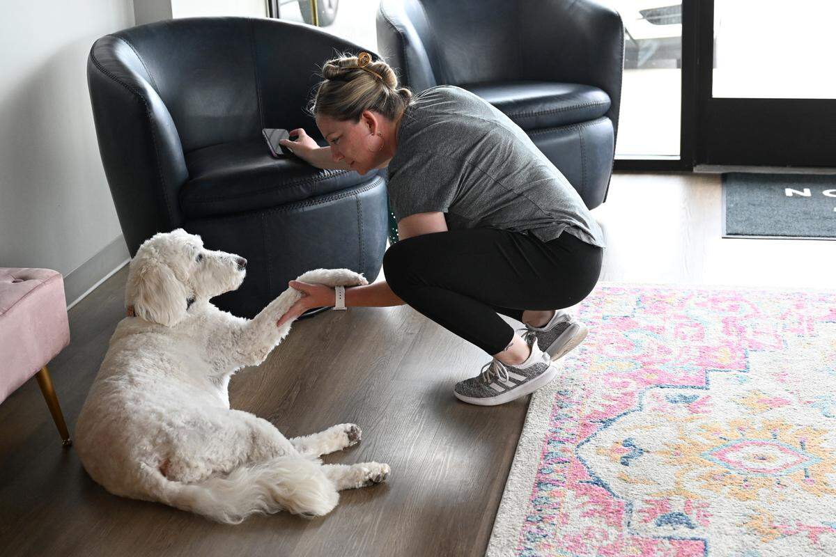 Customer Brittany Allen of Kathleen pets Daffy, the dog of Bonaire Nutrition co-owner Laura Waters inside Bonaire Nutrition in Warner Robins. Waters certified Daffy as an emotional support dog, who has her own bed in Bonaire Nutrition and greets guests.