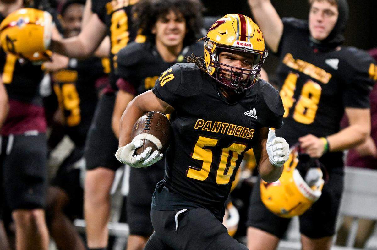 Perry linebacker GeShann Heard (50) runs down the sideline for a touchdown after scooping up a fumbled Panthers’ kickoff return during their GHSA 4A State Championship win over Stockbridge Tuesday in Atlanta.