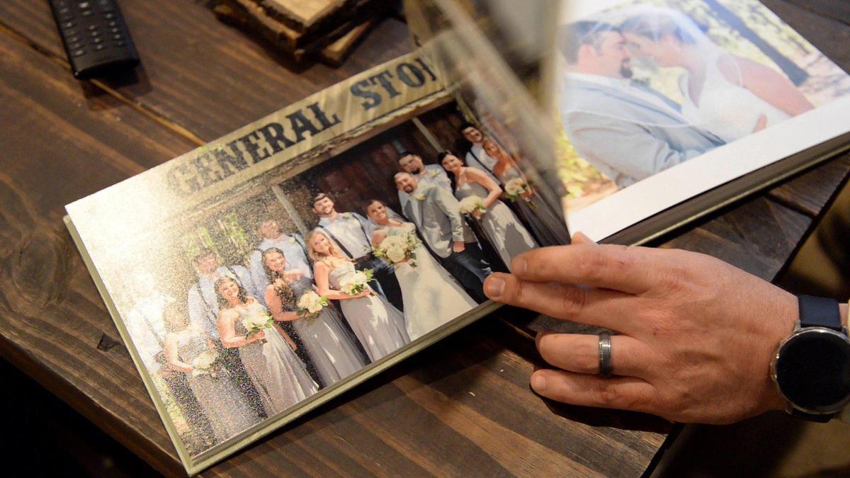 Travis Greene, diagnosed with glioblastoma, flips through a photo book from when he and his wife, Mikayla, got married for the second time on April 1, 2017. The first time they were married was at The Medical Center, Navicent Health on January 18, 2017.