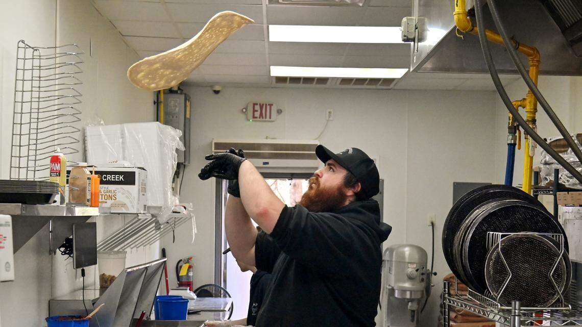 Josh Walsh, co-owner of Cow Pies Pizza Co. at 6001 Watson Blvd. in Byron tosses pizza dough.