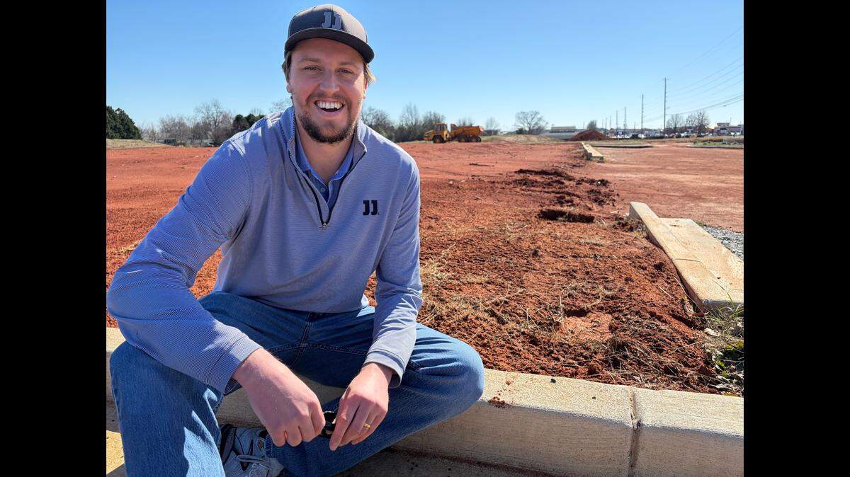 William Amos, who owns and operates multiple Jimmy John’s in Middle Georgia, sits on the curb where his next Jimmy John’s is expected to go into a multi-unit building to be constructed just south of the yet-to-open, new Red Owl Coffee Company.