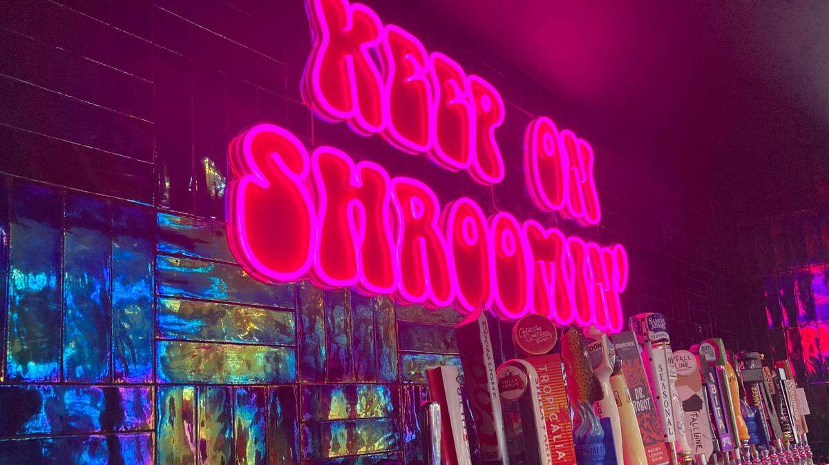 A pink “Keep on Shroomin’” sign hangs above the new draft beer tower at Mellow Mushroom in Warner Robins after a remodel.