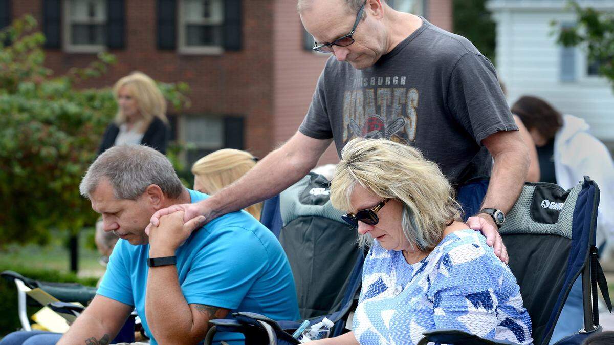 Dan Lowden of Bridgeville, Pennsylvania, supports his friends Sue and Ed Senko as they grieve the loss of their son Ryan during an event organized by Compassionate Friends, which helps parents cope with losing a child. Lowden and his wife, Cindi, lost their son, Jake Hudak, when he was 24.
