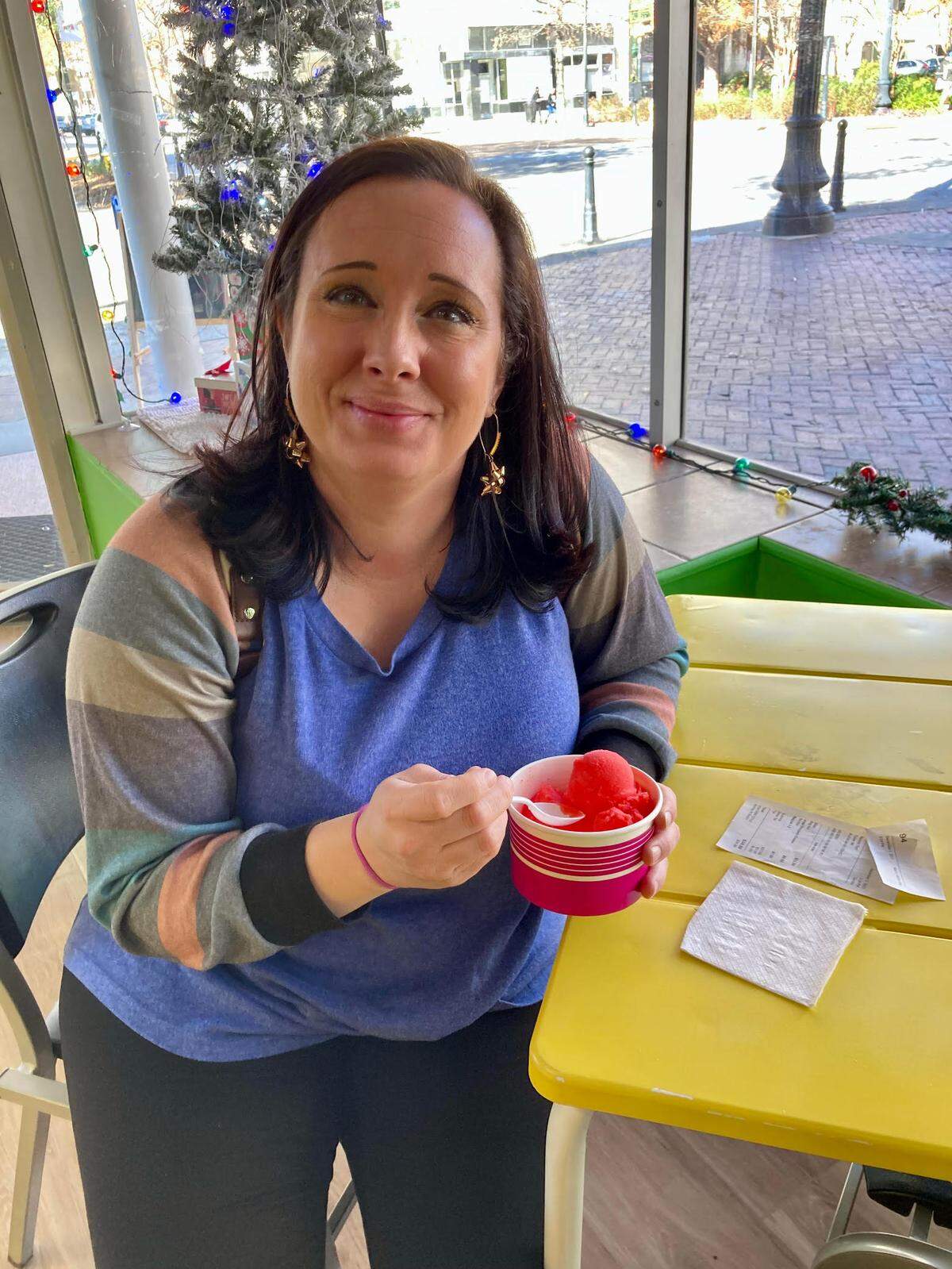 Ashley Doolin, co-owner of Pearl Passionate Cuisine & Cocktails in downtown Macon, enjoys a signature summertime treat from Macon Water Ice in downtown Macon while waiting for a to-go order. “It’s my first one,” Doolin said. “I’ll be back.”