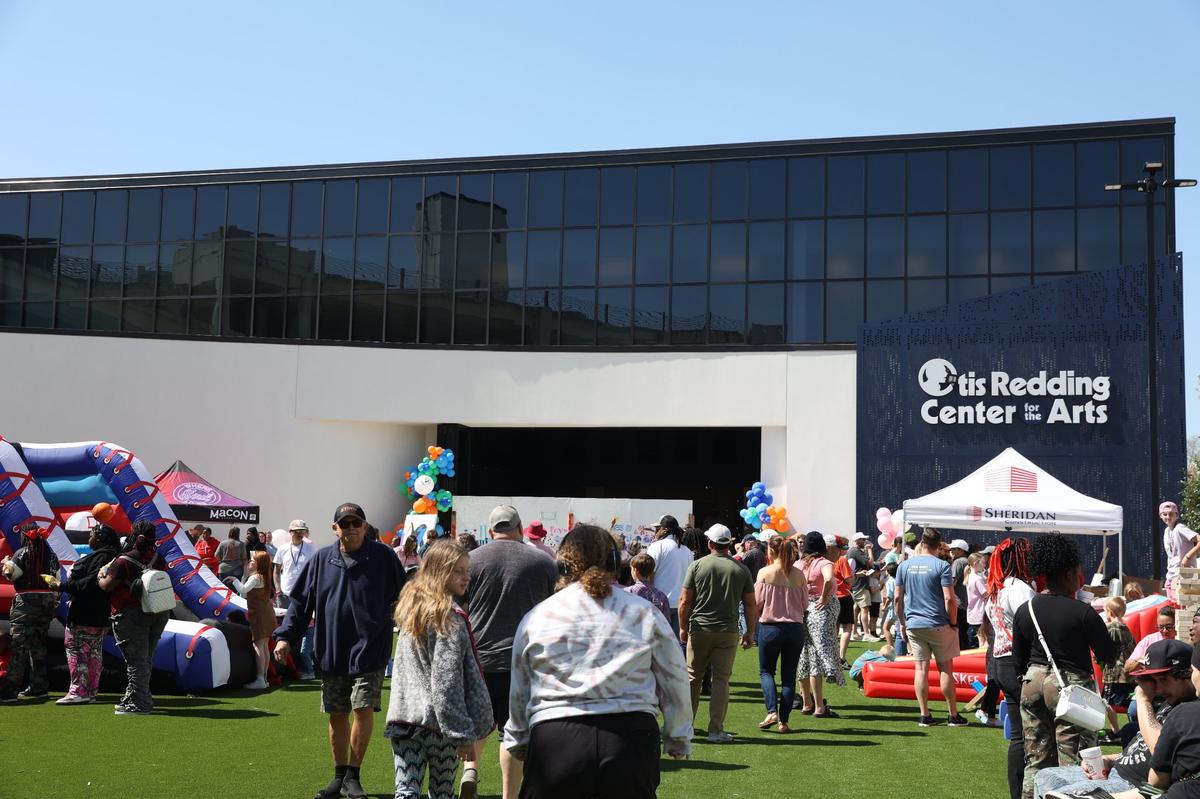 Attendees walk on the front lawn of the newly opened Otis Redding Center for the Arts during the center’s public open house on Saturday, March 22, 2025, off of First Street in downtown Macon, Georgia. The Otis Redding Center for the Arts opened in March 2025 and is the new home for the Otis Redding Foundation’s music camps and youth programming. The building features lab spaces, practice rooms and studio space for students.