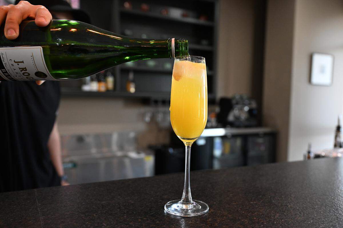 Meridian Brunch & Bar co-owner Diego Gonzalez pours champagne into a mimosa. The new Mexican American brunch restaurant in Perry offers classic and specialty cocktails. 