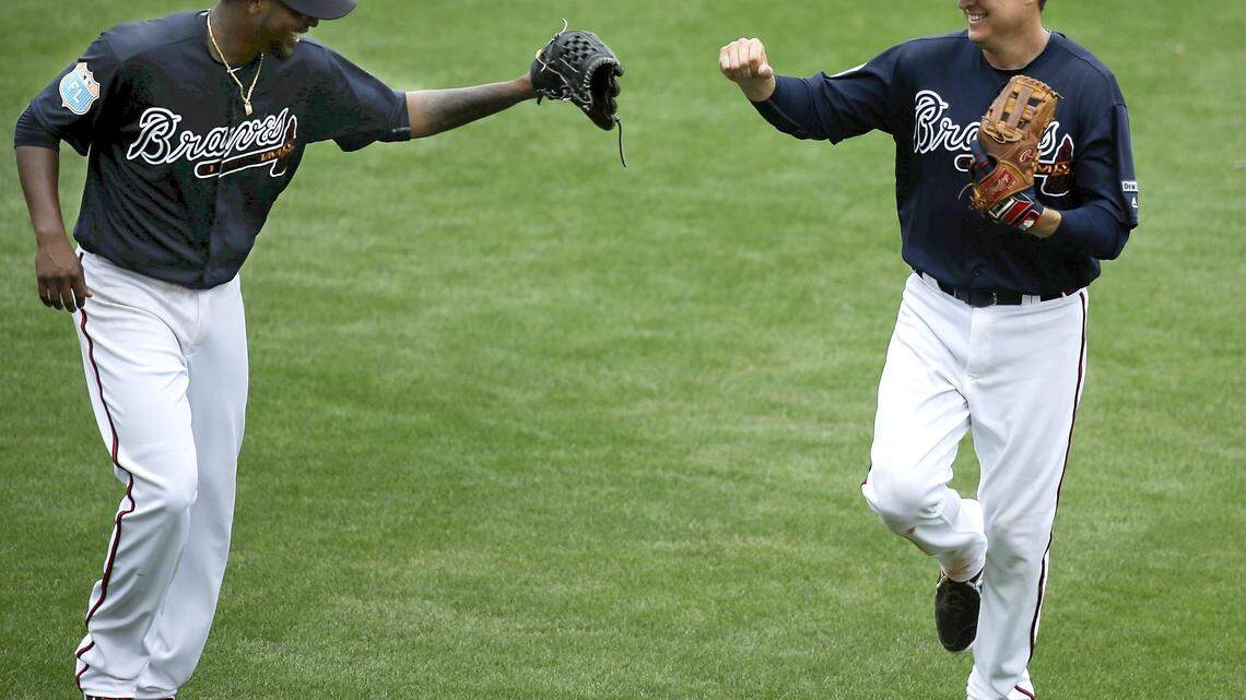 Atlanta Braves starting pitcher Julio Teheran, left, congratulates second baseman Kelly Johnson after Johnson completed an unassisted double play against the Houston Astros in the fifth inning of a spring training baseball game, Friday, March 25, 2016, in Kissimmee, Fla.
