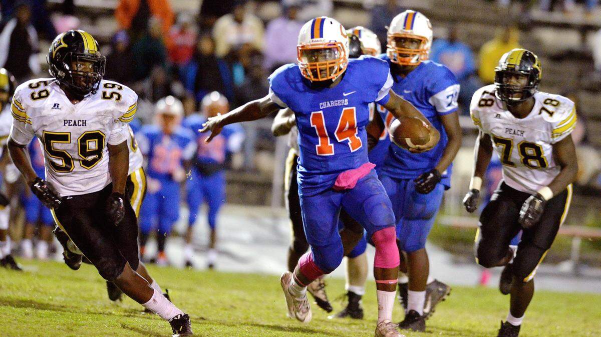 JASON VORHEES/THE TELEGRAPH Macon, GA, 10/02/2015: 
 Central quarterback Derrick Evans (14) runs through a hole in the Peach County defense Friday night.