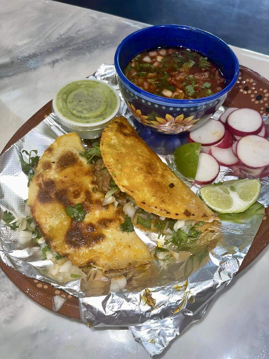 Birria tacos with a bowl of consome, the liquid the birria meat cooks in, for dipping served up at Taqueria la Pina Loka in Warner Robins.