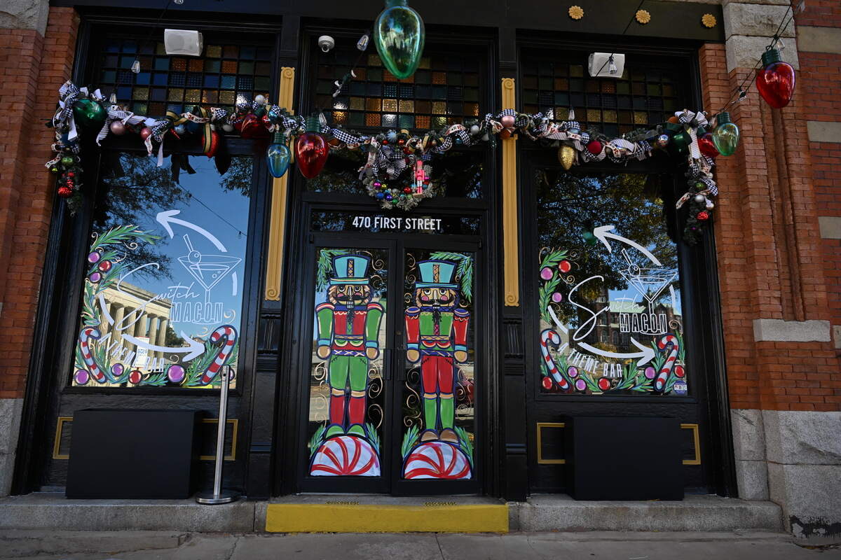 Garland, lights and window paintings hang outside of Switch Macon off of First Street on Tuesday, Nov. 11, 2025, in Macon, Georgia. The new bar, which is set to open next week, will rotate through five seasonal themes throughout the year.