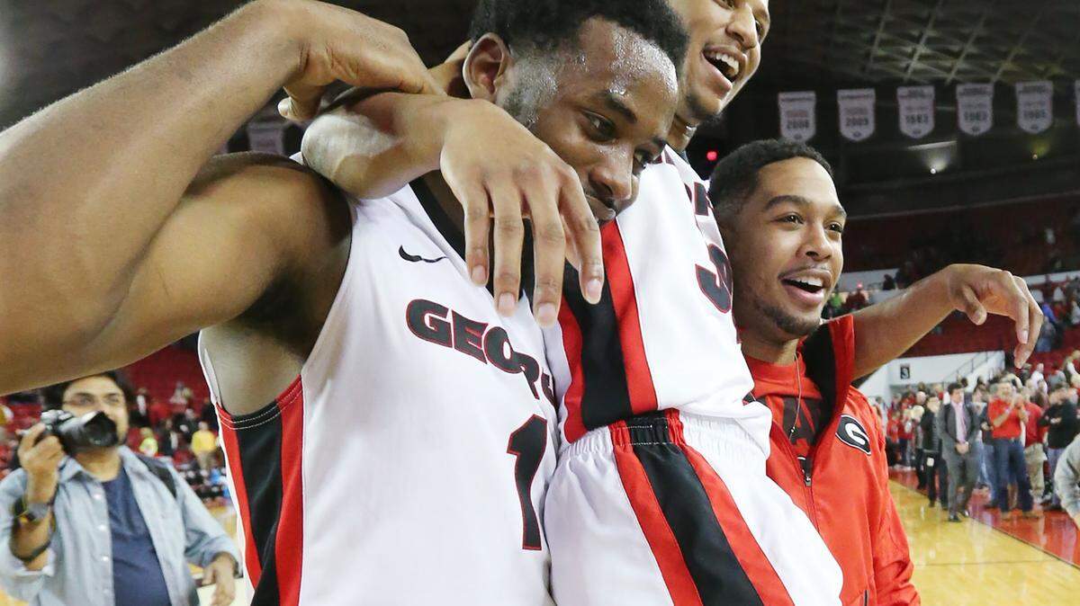 Georgia forward Yante Maten, left, helps carry guard J.J. Frazier, center, off the court after beating state rival Georgia Tech on Saturday in Athens.
