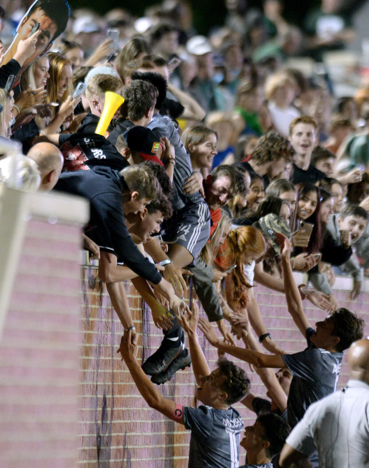 GMC striker Ethan Tolentino (14) leaps into the stands after the BulldogsÕ GHSA 1A State Championship win over ACE Friday night at Mercer.