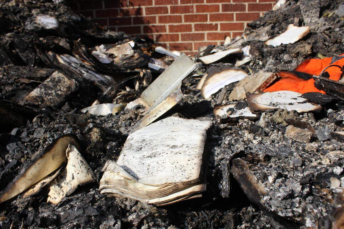 A damaged bible sits among the ashes after a fire at the Byron United Methodist Church in Byron, Georgia. A suspect has been arrested after the fire was allegedly set intentionally.