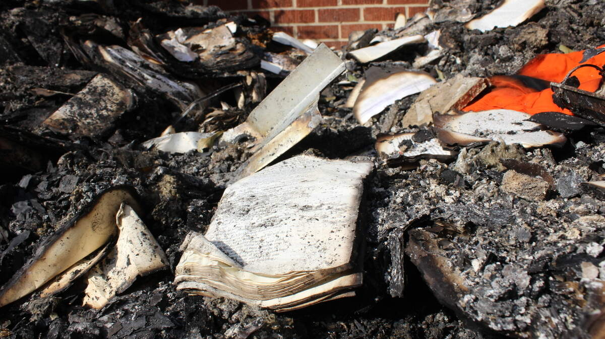 A damaged bible sits among the ashes after a fire at the Byron United Methodist Church in Byron, Georgia. A suspect has been arrested after the fire was allegedly set intentionally.