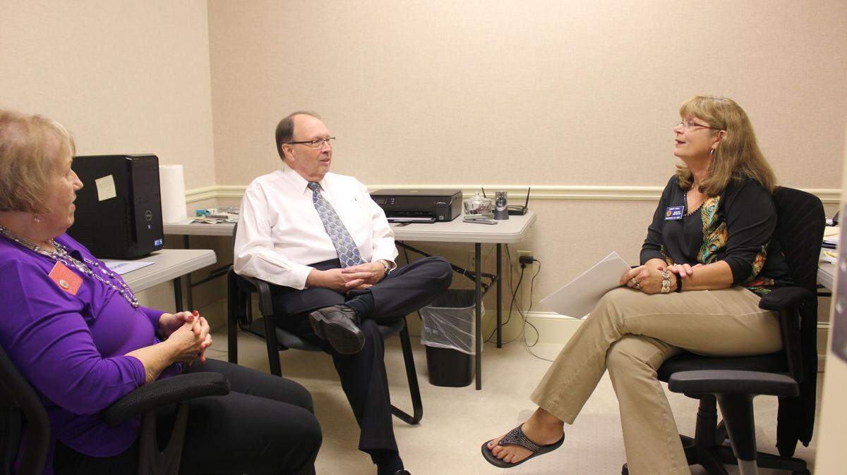 Retired Lt. Gen. Charles Stenner, president of the 21st Century Partnership, speaks with volunteers Lynn Harper, left, and Nancy Hall about work they are doing for the partnership.