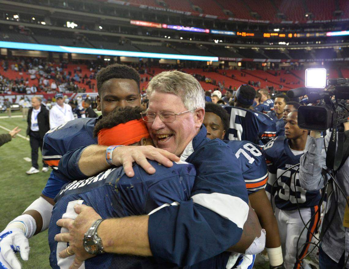 Northside coach Kevin Kinsler embraces running back Willie Jordan after the Eagles won the 2014 GHSA state championship over Mays, 25-18.