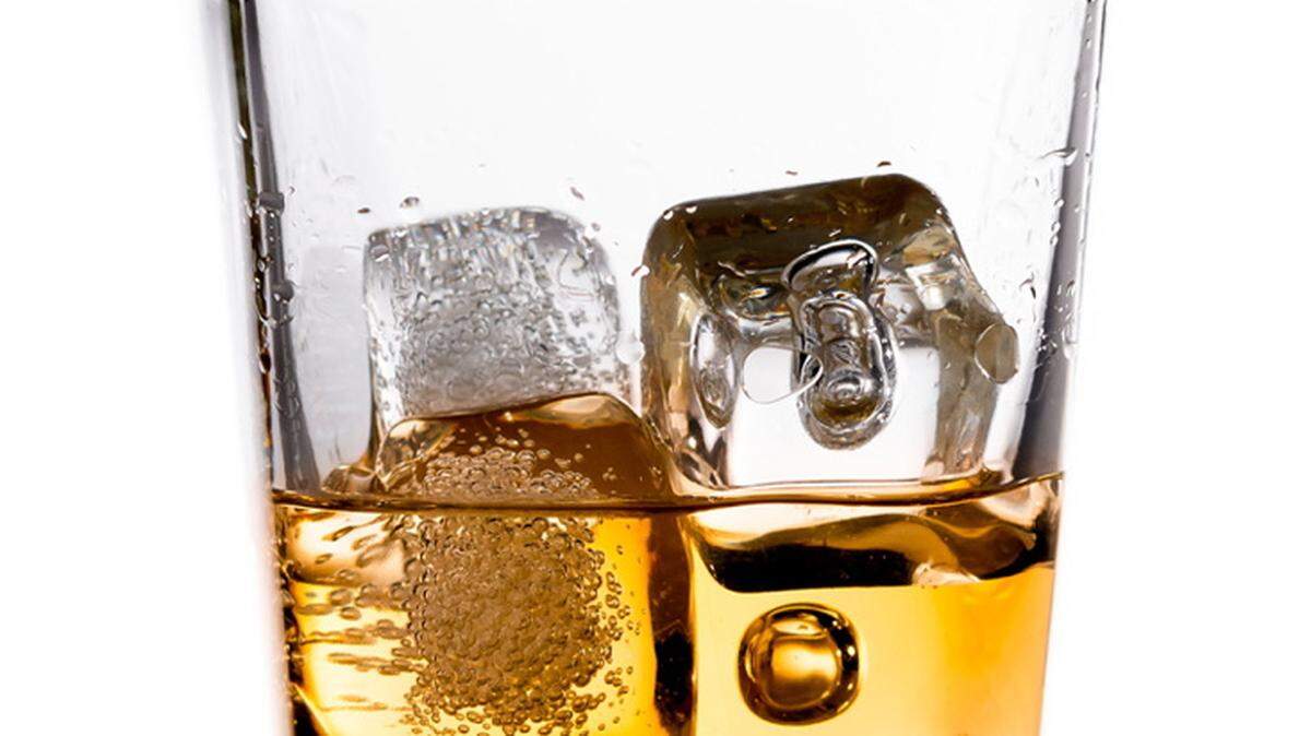 Scotch whiskey in glass with ice cubes.