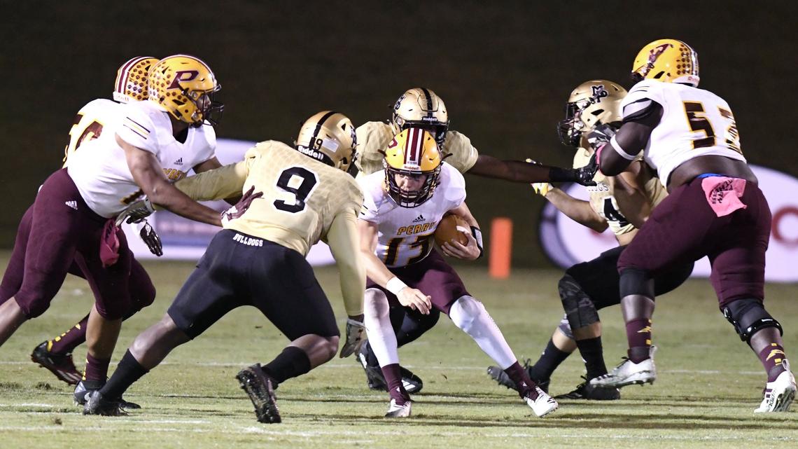 Perry quarterback Lane Rucker (15) attempts to escape pressure from Mary Persons defenders during the first half of their game Friday night.
