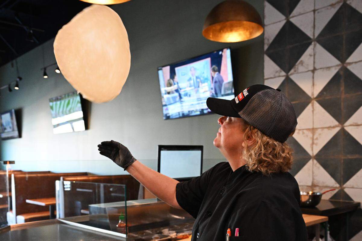 Smokin’ Oak Wood-Fired Pizza and Taproom chief operating officer Linda Black tosses pizza dough at the new Warner Robins franchise location.